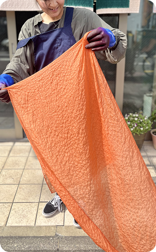染め上げた布を広げる